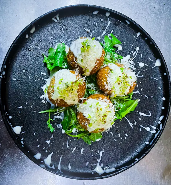 Arancini dello chef on a dark plate at Mascalzone Altona